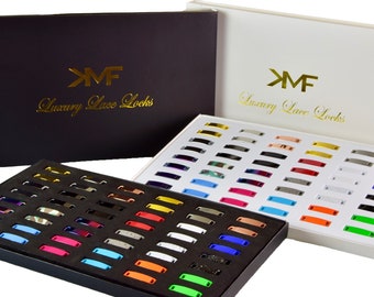 May include: Two open boxes filled with colorful metal lace locks. The boxes are labeled "KMF Luxury Lace Locks".