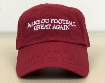 May include: A maroon baseball cap with white embroidered text that reads "Make OU Football Great Again."