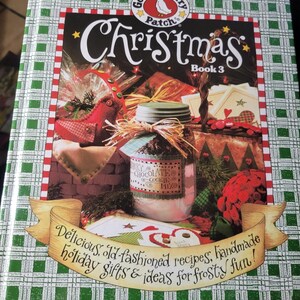 May include: A cookbook titled "Christmas Book 3" by Gooseberry Patch. The cover shows a jar of cookie mix, a red bird ornament, and the text "Delicious, old-fashioned recipes, handmade holiday gifts & ideas for frosty fun!"