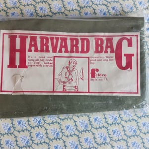 May include: A green Harvard Bag in a plastic wrapper. The bag has a red and white label with the words "HARVARD BAG" and an illustration of a person. The label also states the bag is made of vinyl-backed rayon with a nylon drawstring.