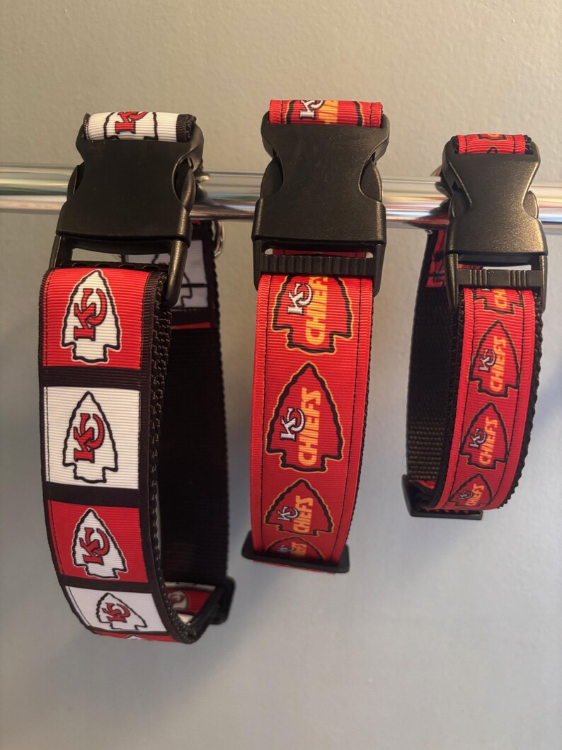 Puede incluir: Tres collares de perro rojos, blancos y amarillos con hebillas negras. Los collares presentan el logotipo de los Kansas City Chiefs y las palabras "KC Chiefs".