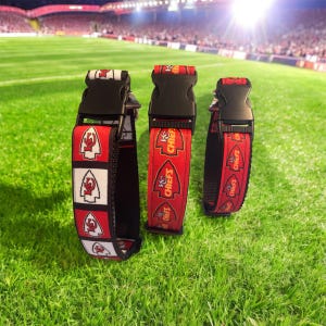 May include: Three red, white, and black dog collars with a Kansas City Chiefs logo and the words "Chiefs" printed on them. The collars have black adjustable buckles.
