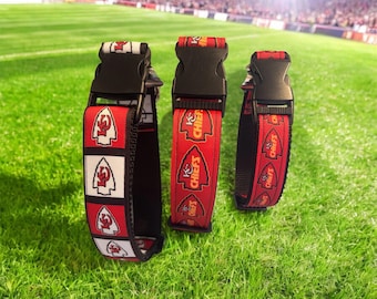May include: Three red, white, and black dog collars with a Kansas City Chiefs logo and the words "Chiefs" printed on them. The collars have black adjustable buckles.