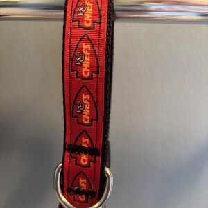 Puede incluir: Collar para perro rojo y negro con un patr&oacute;n repetido del logotipo de los Kansas City Chiefs y las palabras "Chiefs" en amarillo.