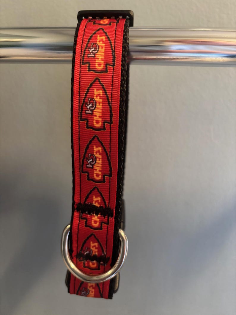 Puede incluir: Collar para perro rojo y negro con un patr&oacute;n repetido del logotipo de los Kansas City Chiefs y las palabras "Chiefs" en amarillo.