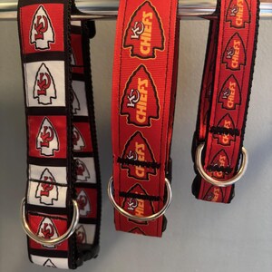 Puede incluir: Tres collares de perro rojos, blancos y negros con anillas en D plateadas. Los collares presentan un patr&oacute;n repetido de una punta de flecha roja con las palabras "K.C. Chiefs" en amarillo.