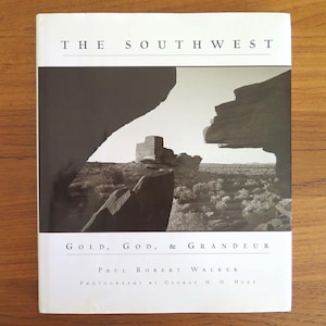 May include: A book titled "THE SOUTHWEST" with a black and white photograph of a desert landscape. The book's title is in large, bold letters. The book's subtitle reads "GOLD, GOD, & GRANDEUR".