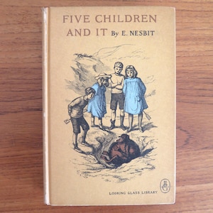 May include: Vintage book cover for "Five Children and It" by E. Nesbit. The cover features an illustration of five children looking at a creature in a hole. The book is from the Looking Glass Library.