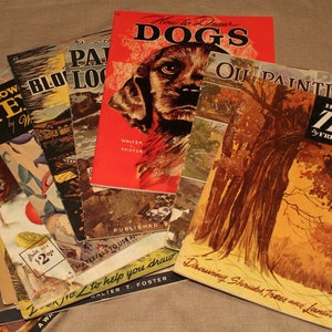 以下が含まれることがあります： 「犬の描き方」「木の描き方」「風景画」などのタイトルがついた、ビンテージの描き方に関する本が積み重ねられています。本は、犬、木、風景のイラストが描かれたカラフルな表紙をしています。