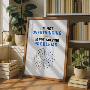 以下が含まれることがあります： 黒と青のテキスト「I'M NOT OVERTHINKING I'M PRE-SOLVING PROBLEMS」が書かれた額縁入りのアートプリント。その下には、半分が有機的で半分がデジタルネットワークで構成された脳のグラフィックが、黒い線と青い点、そしてそれらをつなぐ線で描かれています。