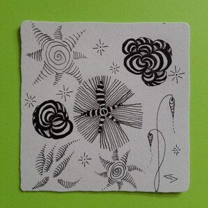 May include: A black and white ink drawing on a white background featuring various abstract shapes and patterns. The drawing includes a spiral, a flower, a star, and a few other abstract shapes.