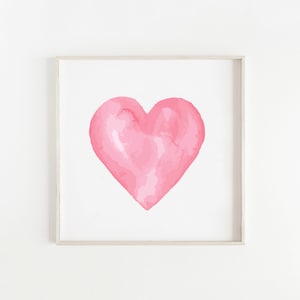 May include: A framed watercolor painting of a pink heart on a white background.