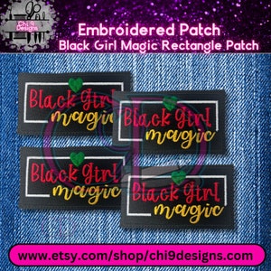 May include: Four black embroidered patches with white outlines. Each patch features the text "Black Girl Magic" in red, yellow, and green lettering with a green heart.