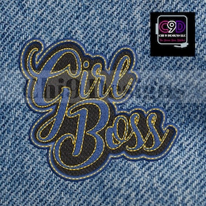 May include: A blue and black embroidered patch with the text "Girl Boss" in a stylized font. The patch is on a denim background.
