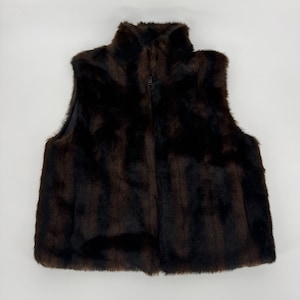 May include: A brown faux fur vest with a high collar and a full-length zipper. The vest is sleeveless and has a soft, textured appearance. The color is a deep, rich brown.