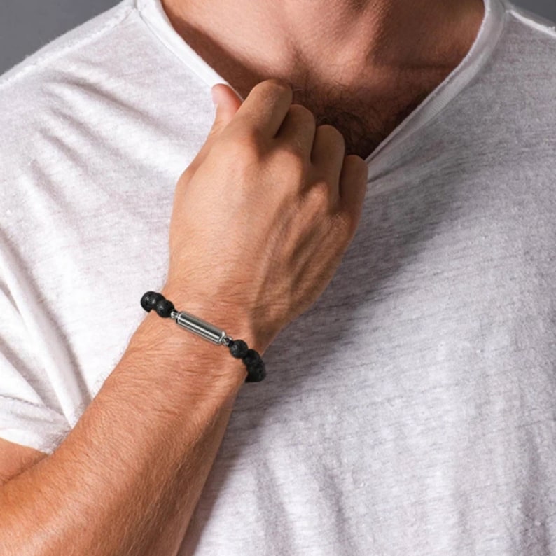 May include: A black lava rock bracelet with a silver magnetic clasp.