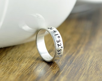 May include: A silver ring with the coordinates "N 41.032° 38.86°" engraved on the band.