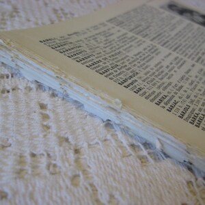 May include: Close-up of the edge of a book with a white cover and black text. The text includes place names like Barel, Barent, Barere de, Barfleur, Barfuruch, Bari, Barika, Barjac, Barjols, Barka, Bar-le-Duc, and Barkla.
