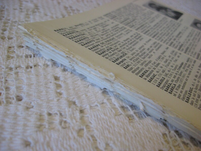 May include: Close-up of the edge of a book with a white cover and black text. The text includes place names like Barel, Barent, Barere de, Barfleur, Barfuruch, Bari, Barika, Barjac, Barjols, Barka, Bar-le-Duc, and Barkla.