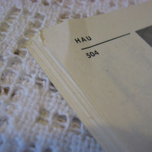 May include: Close-up of a book page with the text "HAU 504" printed on it.