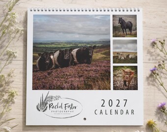May include: A 2027 wall calendar featuring photography by Rachel Foster. The cover displays a large landscape image of cows in a field of purple heather, alongside three smaller photos of a horse, sheep, and a piglet. The text reads 2027 CALENDAR.