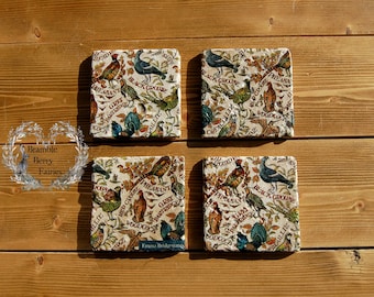 May include: Set of four square ceramic coasters with a vintage bird and floral design. The coasters feature a variety of birds, including pheasants, grouse, and partridges, with their names printed in red lettering. The background is a cream color with brown and green floral accents.