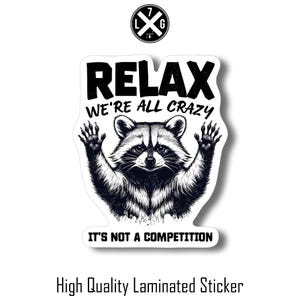 May include: A white sticker with a black and white illustration of a raccoon with the text "Relax We're All Crazy It's Not A Competition".
