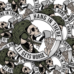 May include: A sticker featuring a skull wearing a military helmet, drinking from a mug. The text "HANG IN THERE" and "IT GETS WORSE" are prominently displayed. The design is repeated across the sticker's surface, creating a pattern.