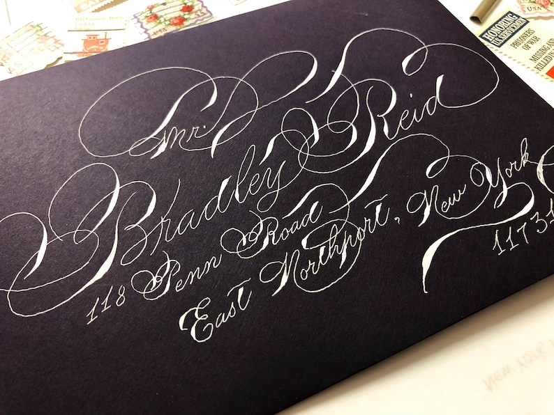 Purple A7 envelopes with white ink in highly flourished calligraphy stylish fun Handwritten wedding envelopes Spencerian script