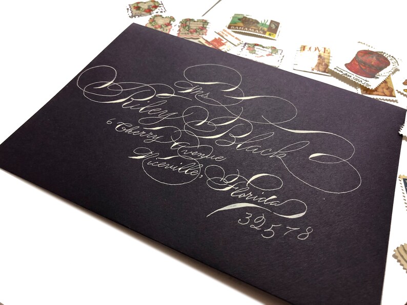 Purple A7 envelopes with white ink in highly flourished calligraphy stylish fun Handwritten wedding envelopes Spencerian script