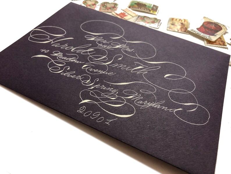 Purple A7 envelopes with white ink in highly flourished calligraphy stylish fun Handwritten wedding envelopes Spencerian script