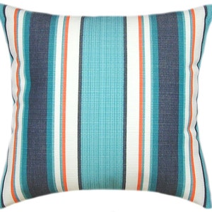 Puede incluir: Una almohada de rayas con rayas de color azul verdoso, azul marino, blanco y naranja. La almohada est&aacute; hecha de una tela suave y texturizada.