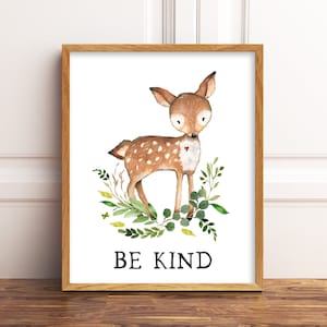 May include: A watercolor illustration of a brown deer with white spots standing in a circle of green leaves. The deer has a small red heart on its chest. The text "BE KIND" is printed below the deer.