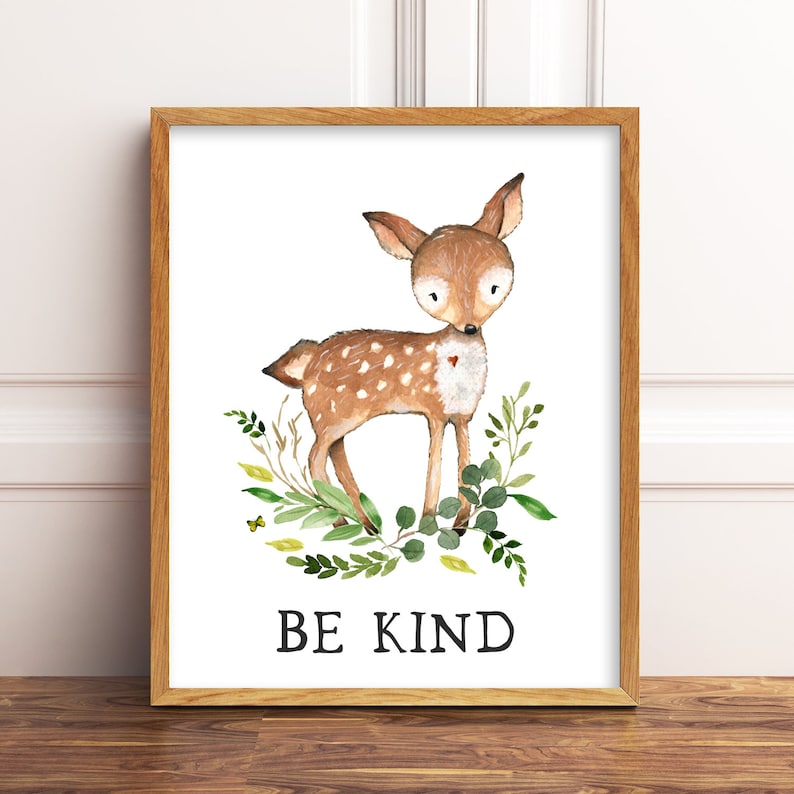 May include: A watercolor illustration of a brown deer with white spots standing in a circle of green leaves. The deer has a small red heart on its chest. The text "BE KIND" is printed below the deer.