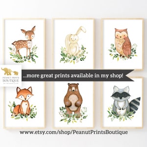 May include: Set of six watercolor animal prints featuring a deer, rabbit, owl, fox, bear, and raccoon. Each animal is surrounded by green foliage. The prints are perfect for a nursery or child's room.