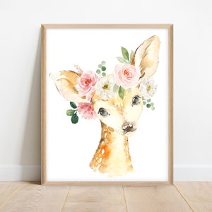 May include: A watercolor painting of a fawn with a floral crown. The fawn has a light brown coat and large, dark eyes. The crown is made of pink and white flowers, with green leaves.