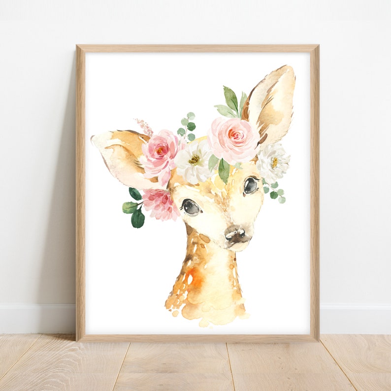 May include: A watercolor painting of a fawn with a floral crown. The fawn has a light brown coat and large, dark eyes. The crown is made of pink and white flowers, with green leaves.