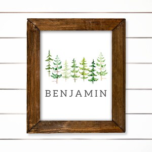 May include: A framed print with a watercolor illustration of a row of green pine trees and the name "BENJAMIN" printed below.
