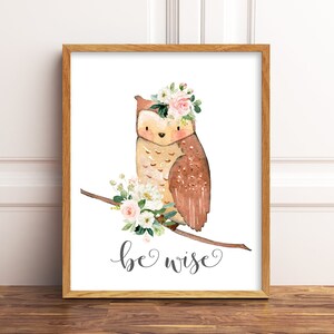 May include: A watercolor illustration of an owl wearing a pink flower crown, perched on a branch with white and pink flowers. The text "be wise" is written below the owl.