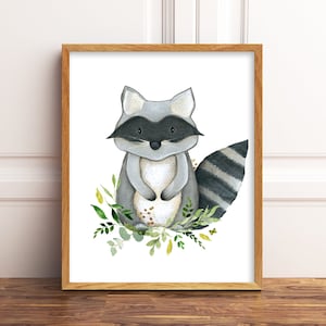 K&ouml;nnte beinhalten: Eine Aquarell-Illustration eines Waschb&auml;ren mit einem schwarz-wei&szlig; gestreiften Schwanz, der auf einem Bett aus gr&uuml;nen Bl&auml;ttern und Blumen steht. Der Waschb&auml;r hat eine schwarze Maske um die Augen und schaut direkt auf den Betrachter.