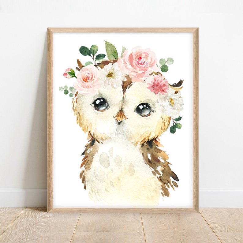 May include: A watercolor painting of a brown and white owl with large eyes wearing a pink and white flower crown. The owl is looking directly at the viewer.