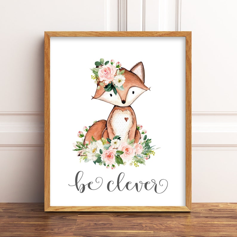 May include: A watercolor illustration of a fox wearing a pink flower crown. The fox is sitting on a bed of pink and white flowers. The text "be clever" is written below the fox.