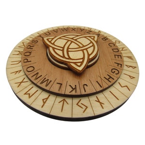 Può includere: Una ruota di cifratura circolare in legno con un design a nodo celtico al centro. L'anello esterno presenta l'alfabeto inglese, mentre l'anello interno presenta le rune dell'Elder Futhark.