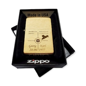 Puede incluir: Encendedor Zippo dorado con una inscripci&oacute;n personalizada. La inscripci&oacute;n incluye el texto "Geodatischer Eppendorf", "Referenzpunkt Freistaat Sachsen", "Georg Karl" y "28.06. 1957".