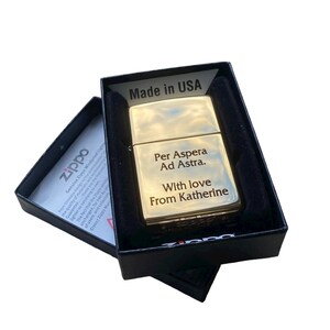 Puede incluir: Encendedor Zippo dorado en una caja negra con la inscripci&oacute;n "Per Aspera Ad Astra. With love from Katherine" en la parte delantera.
