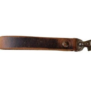 May include: A brown leather key chain with a silver metal clasp.