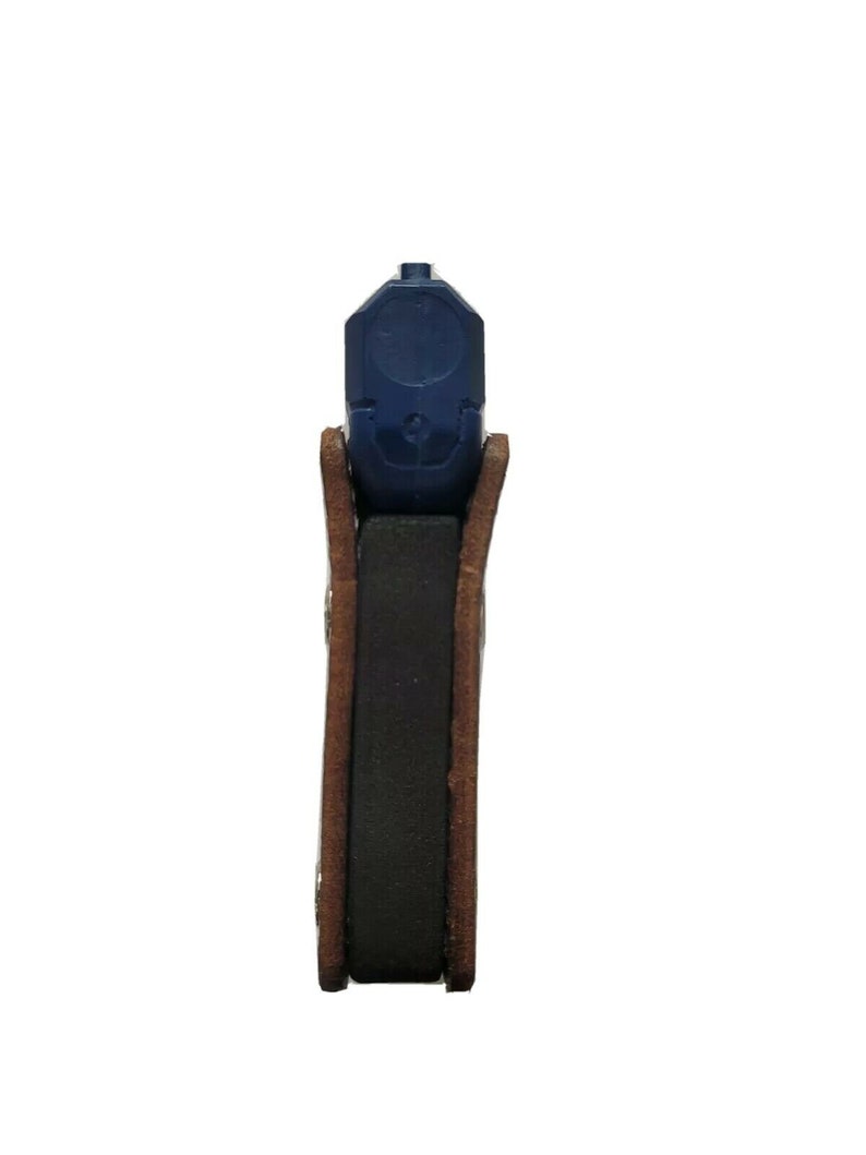 Puede incluir: Una pistola azul es parcialmente visible, dentro de una funda de cuero marr&oacute;n. La funda tiene un inserto rectangular oscuro, probablemente para mayor comodidad o protecci&oacute;n. La imagen est&aacute; sobre un fondo blanco.