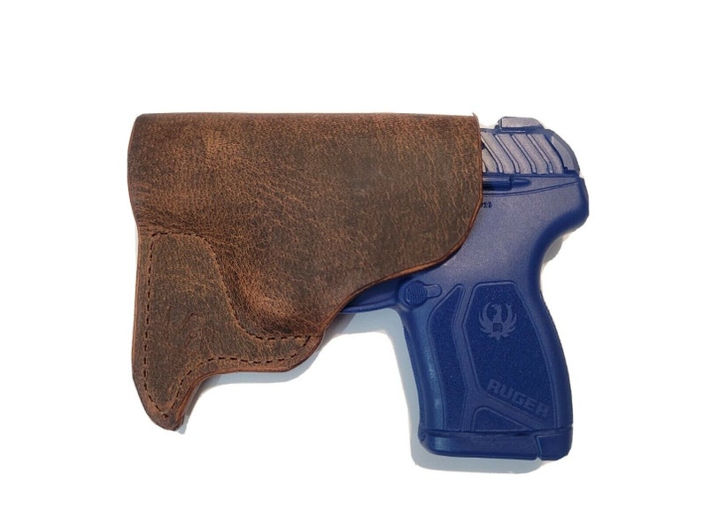 May include: A brown leather holster for a blue Ruger pistol.