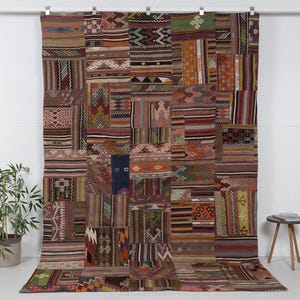 Può includere: Un grande tappeto rettangolare patchwork con una varietà di colori e motivi. Il tappeto è composto da molti pezzi di tessuto diversi, ognuno con il suo design unico. Il tappeto è un bellissimo esempio dell'artigianato tradizionale turco.