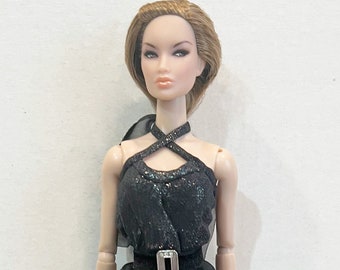 May include: A fashion doll with brown hair wearing a black halter top with a sparkly texture and a black skirt with a silver belt.